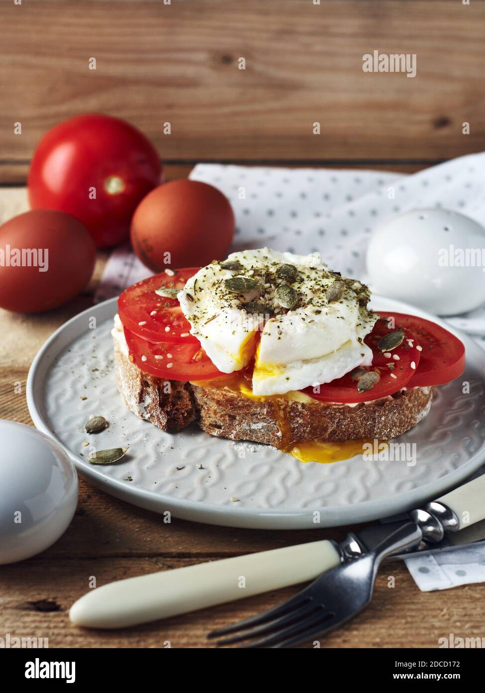 Offenes Sandwich, Toast mit Tomaten und pochiertem Ei. Stockfoto
