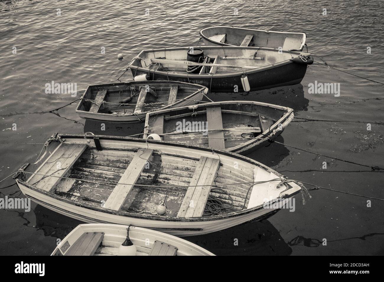 Eine Reihe von hölzernen Dingys schwimmt im Hafen von St. Ives Stockfoto