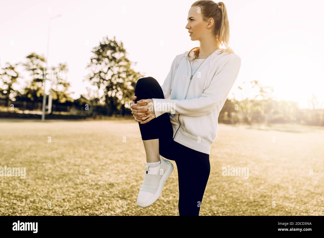 Schlanke Mädchen Athlet in Sportkleidung, Stretching am Morgen in der Morgendämmerung Stockfoto