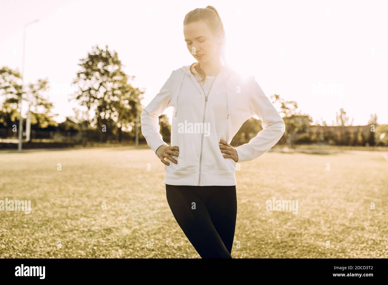 Schlanke Mädchen Athlet in Sportkleidung, Stretching am Morgen in der Morgendämmerung Stockfoto
