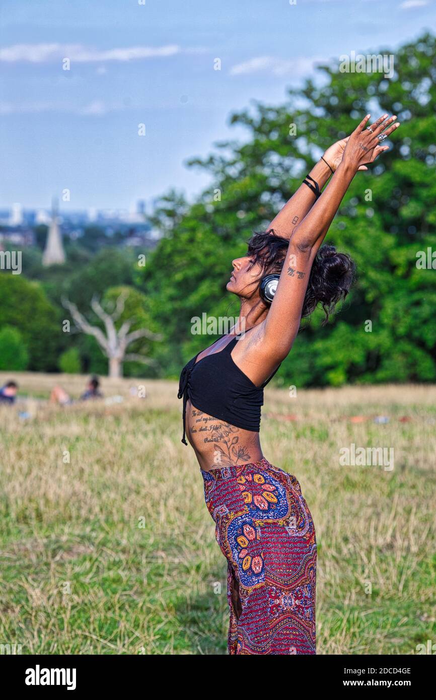 GROSSBRITANNIEN / England / London / Hampstead Heath / Ecstatic Dance London Event . Tänzerin mit geräuschlosen Disco-Kopfhörern. Stockfoto