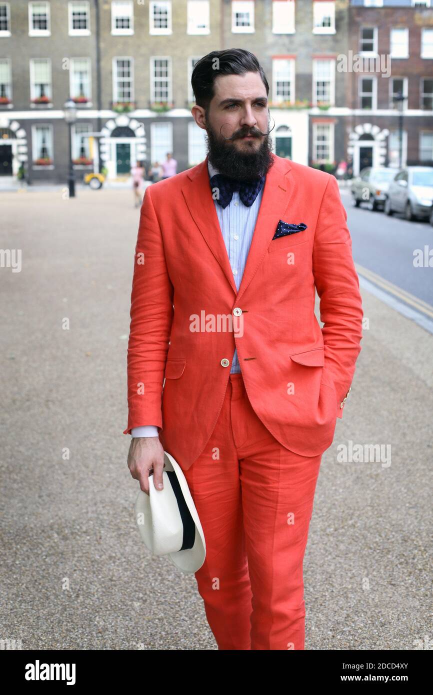 Großbritannien /London /Modeportrait eines hübschen jungen Hipstermannes, der im roten Anzug im Freien läuft. Stockfoto