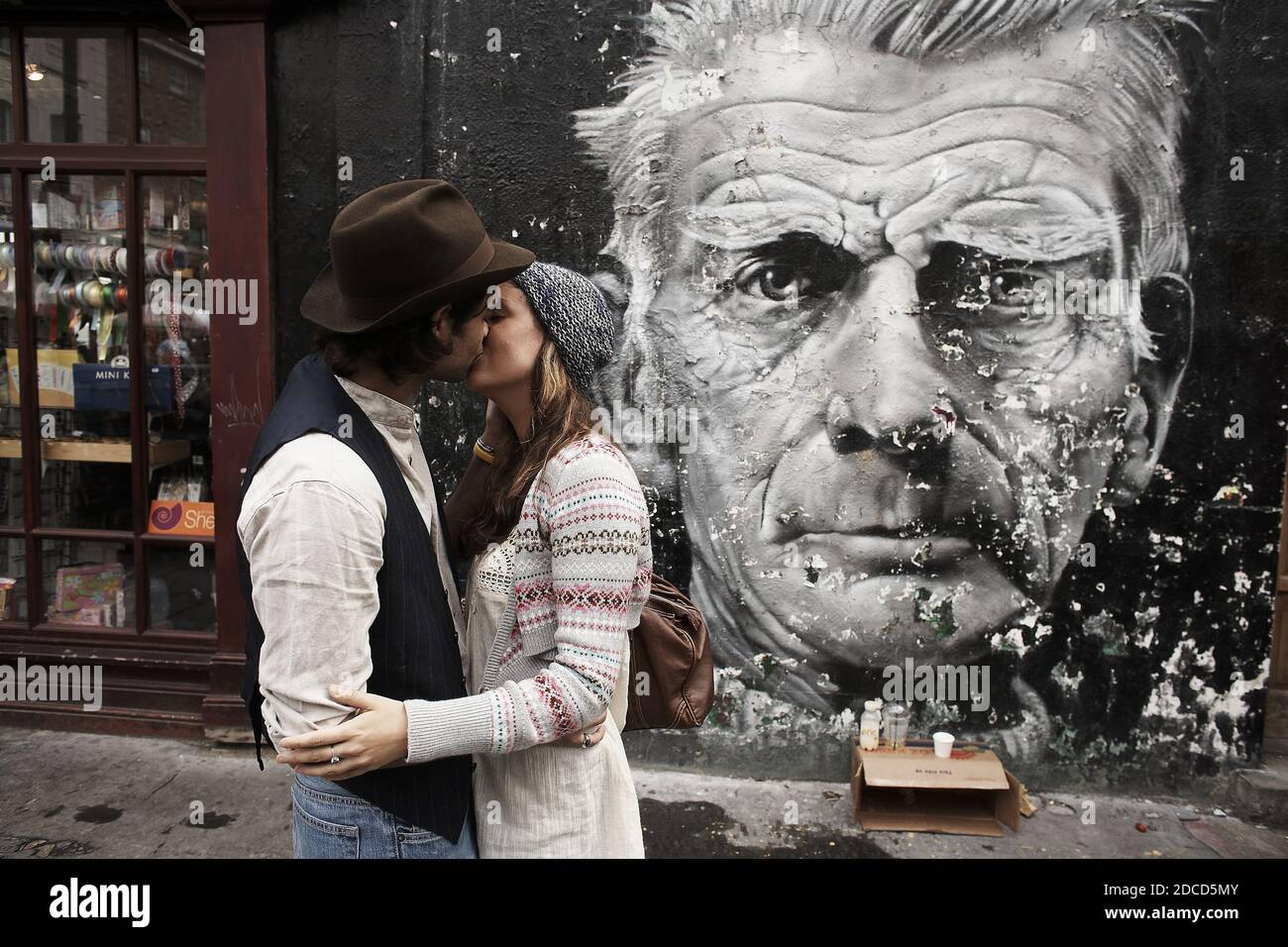 GROSSBRITANNIEN /, London, Notting Hill/ EIN junges kaukasisches Paar, das vor einem Samuel Becket Graffiti auf dem Portobello Market küsst. Stockfoto