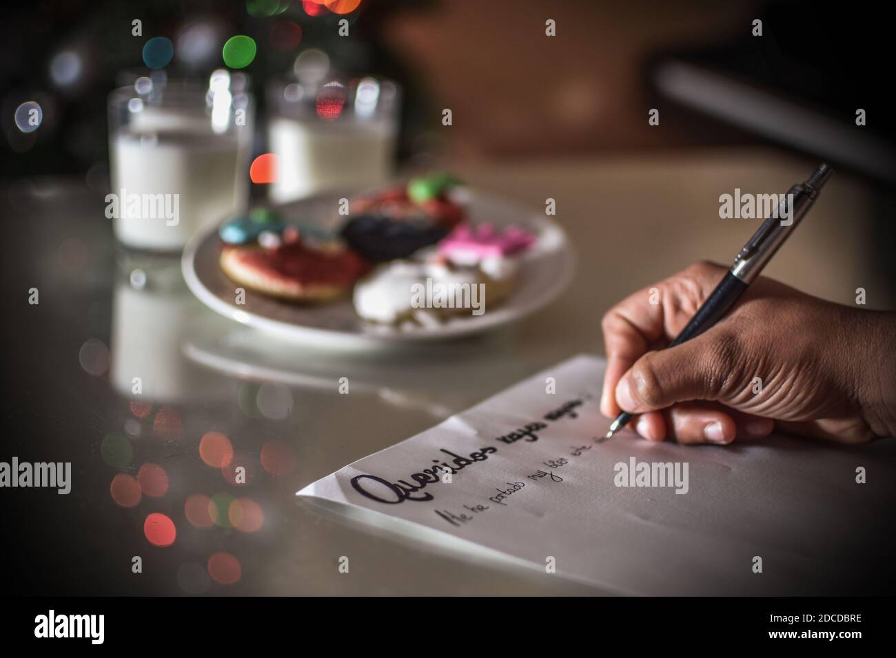 FELIZ DIA DE LOS REYES MAGOS, spanische Übersetzung von GLÜCKLICHEN WEISEN TAG: Kind writting a Letter with the words 'QueridosReyes magos' Stockfoto