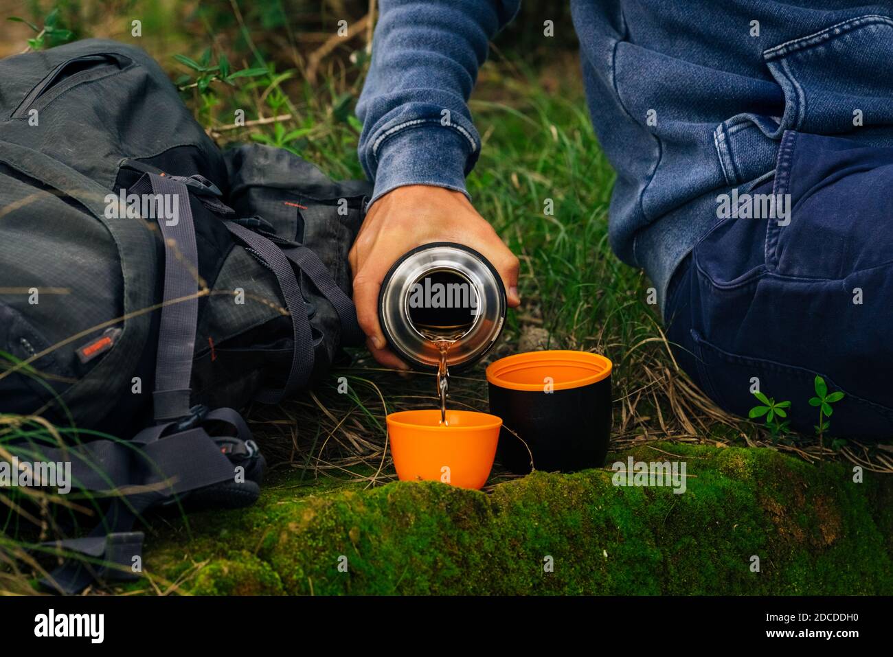 Trinken Sie Tee aus Thermoskannen während der Wanderung. Mann Hand Gießen heißen Tee aus Thermoskannen Stockfoto