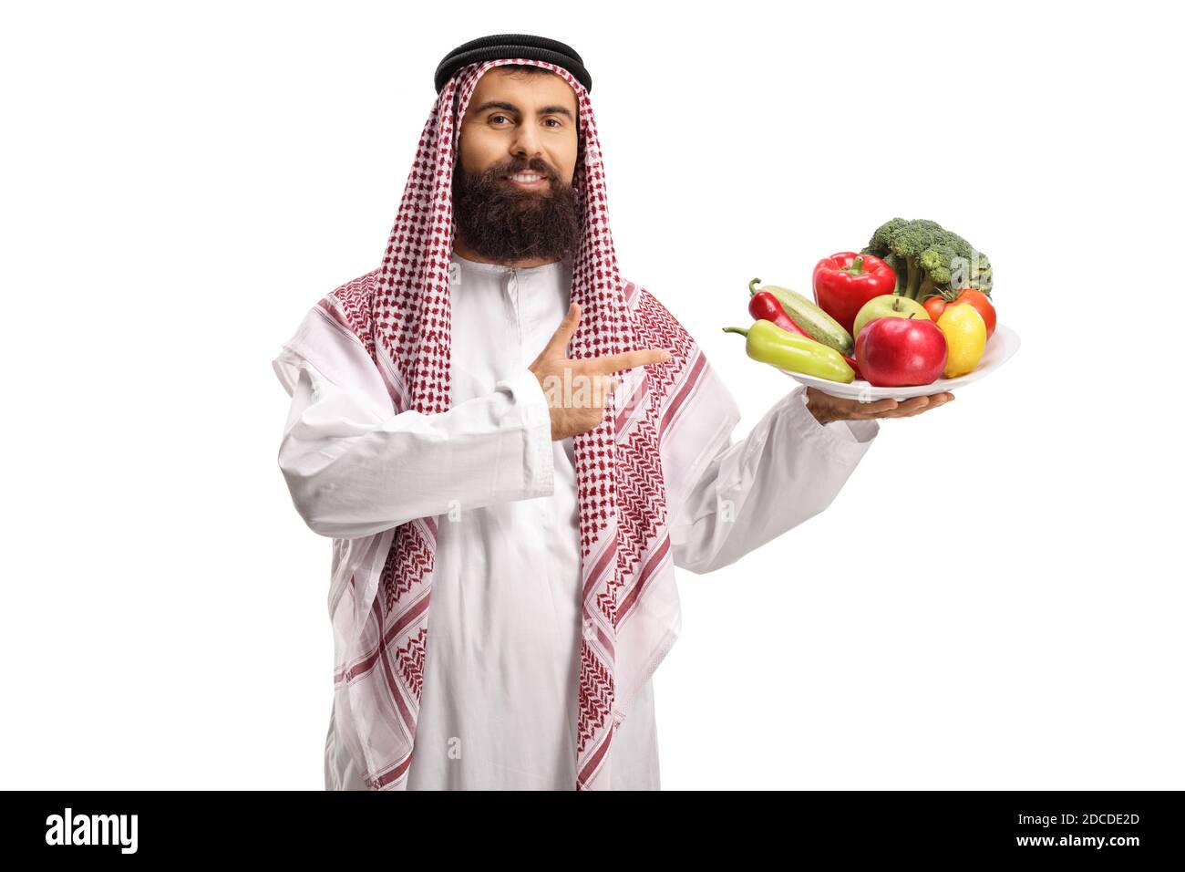 Saudi-arabischer Mann hält einen Teller mit Obst und Gemüse Und zeigt auf sie isoliert auf weißem Hintergrund Stockfoto