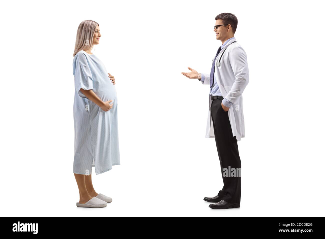 In voller Länge Profilaufnahme eines männlichen Arztes im Gespräch mit Eine schwangere Patientin in einem Krankenhauskleid isoliert auf Weißer Hintergrund Stockfoto