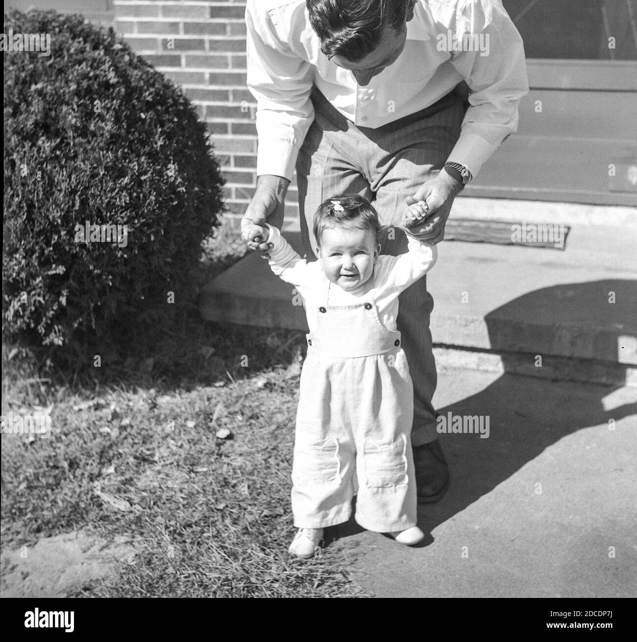 Der junge Vater spielt mit seiner kleinen Tochter vor ihrer bescheidenen Heimat USA 1949 Stockfoto