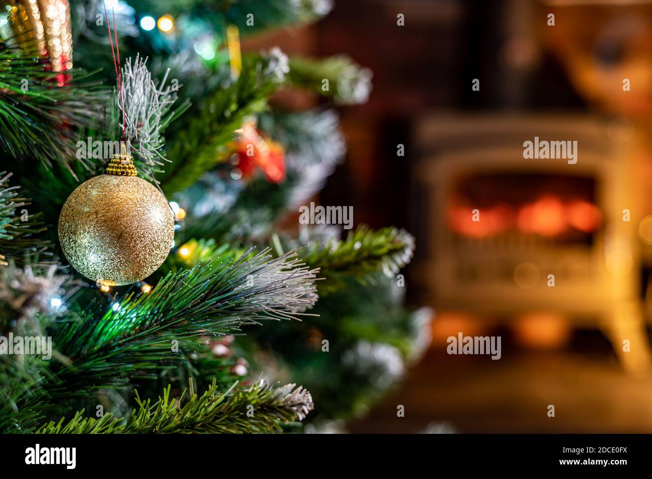 Nahaufnahme von weihnachtsbaum Blasen mit verwischtem Feuer im Hintergrund. Home Wohnzimmer flache Tiefe des Feldes Stockfoto