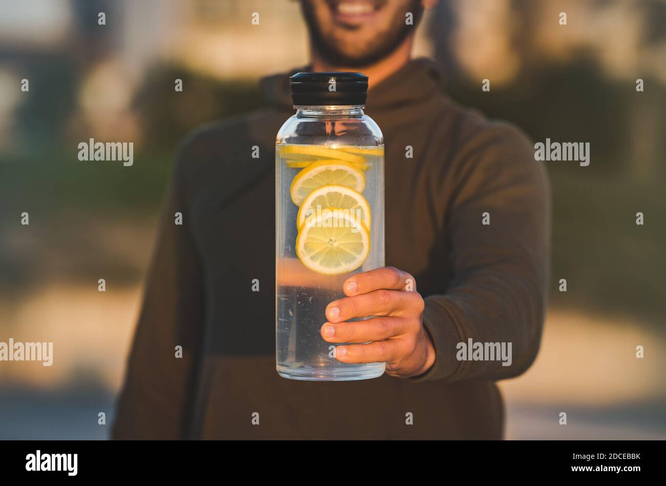 Mann mit einer Flasche frisches Zitronenwasser. Gesunde Getränke, Ernährung und Entgiftung Konzept Stockfoto