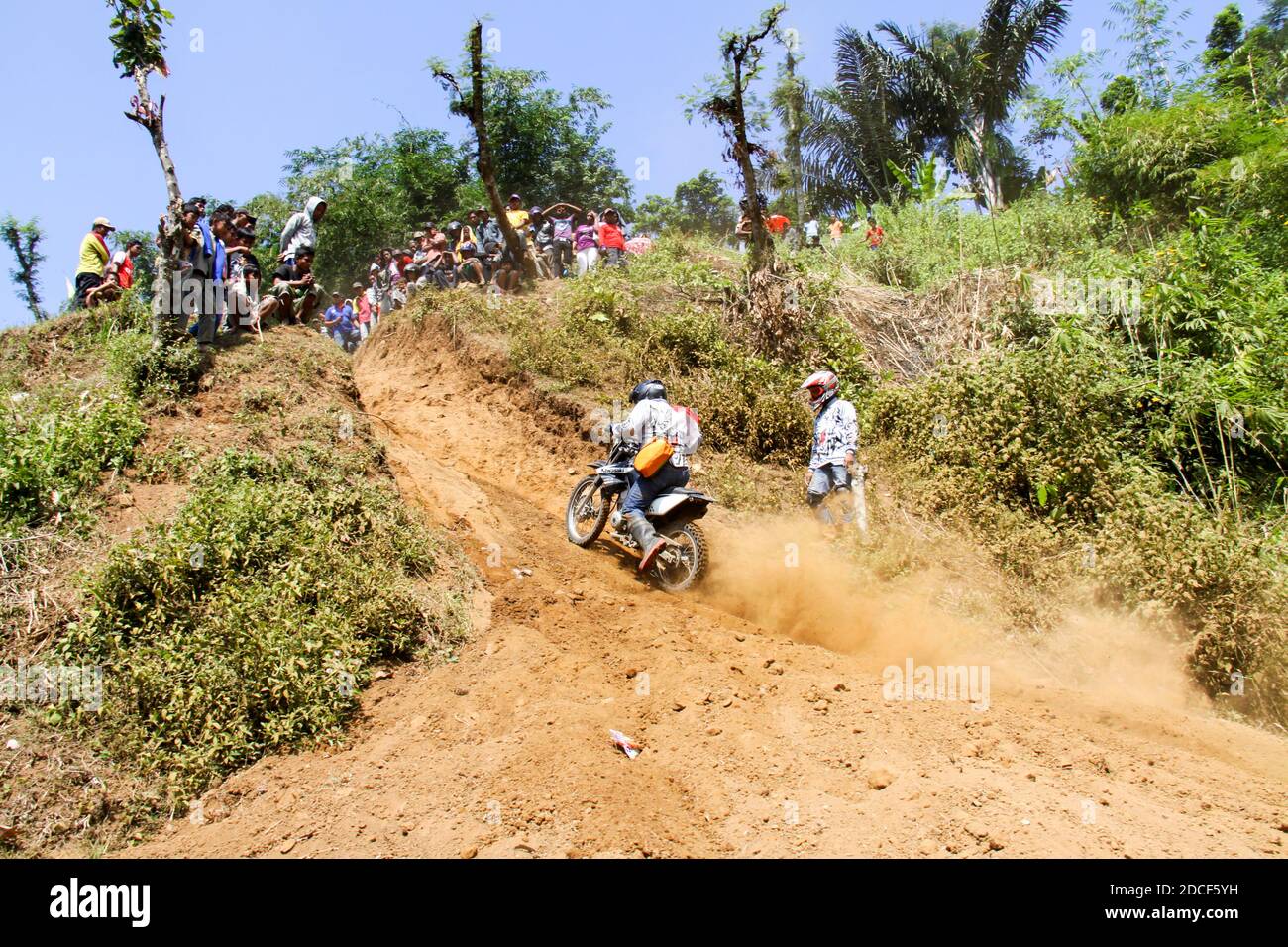 Ein Teilnehmer am Jember Adventure Trail fiel auf eine Steigung. Stockfoto