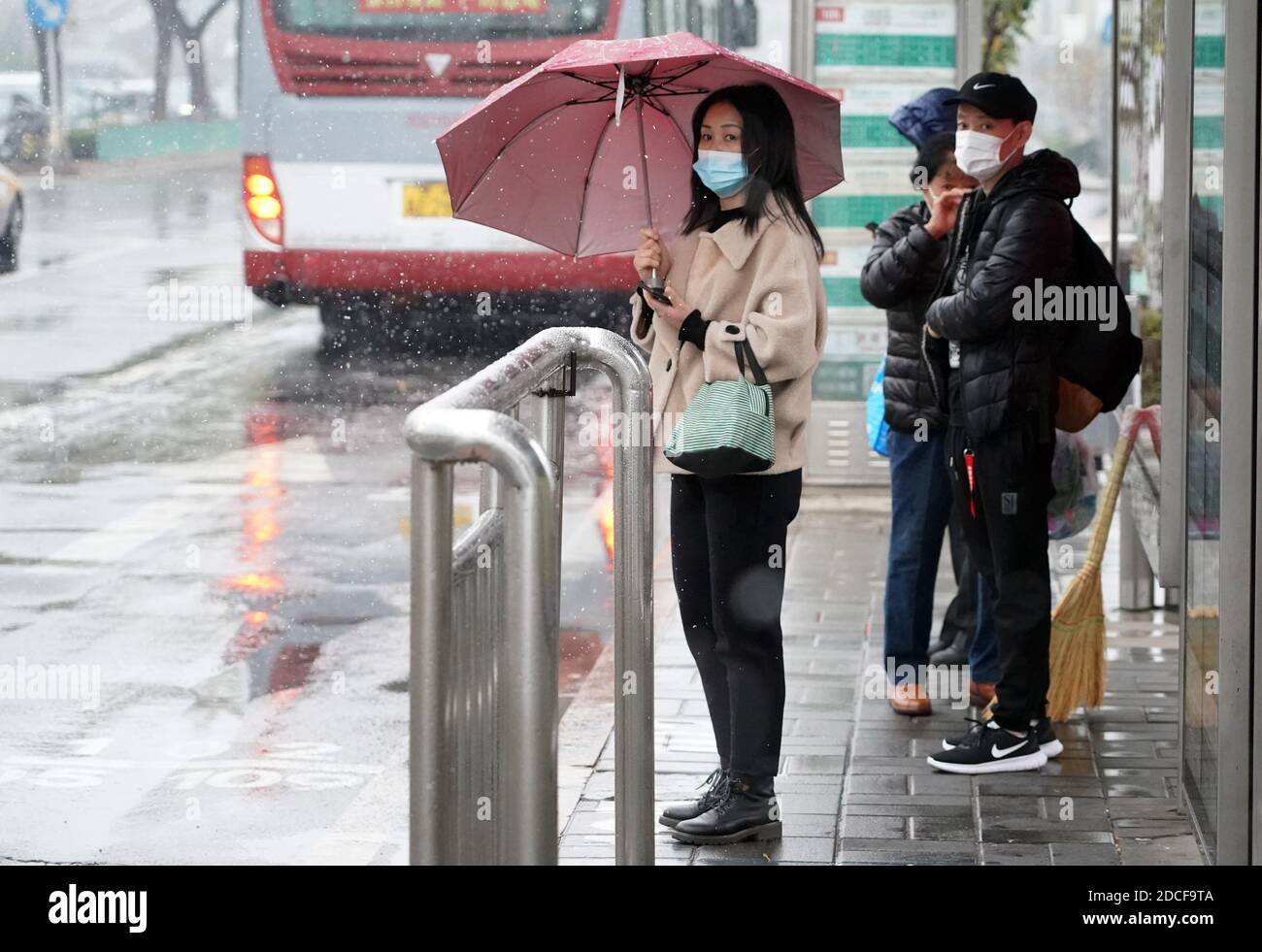 Peking, China. November 2020. Man sieht Menschen, die an einer Bushaltestelle in Peking, der Hauptstadt Chinas, am 21. November 2020 warten. Peking erlebte am Samstag einen Schneefall. Quelle: Ren Chao/Xinhua/Alamy Live News Stockfoto