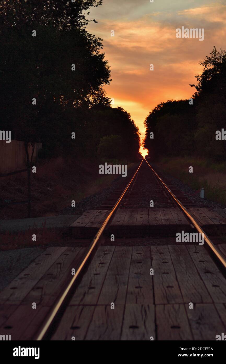 Burlington, Illinois, USA. Unbesetzte Bahngleise erstrecken sich zu einem Fluchtpunkt am Horizont kurz vor Sonnenuntergang. Stockfoto