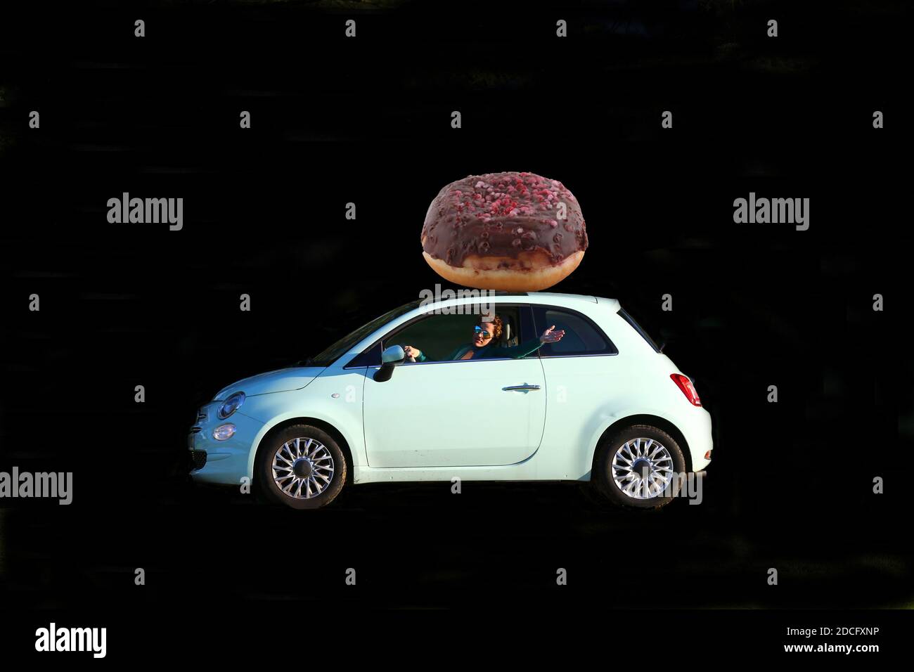 Auto mit Essen auf dem Dach und Frau fahren Stockfoto