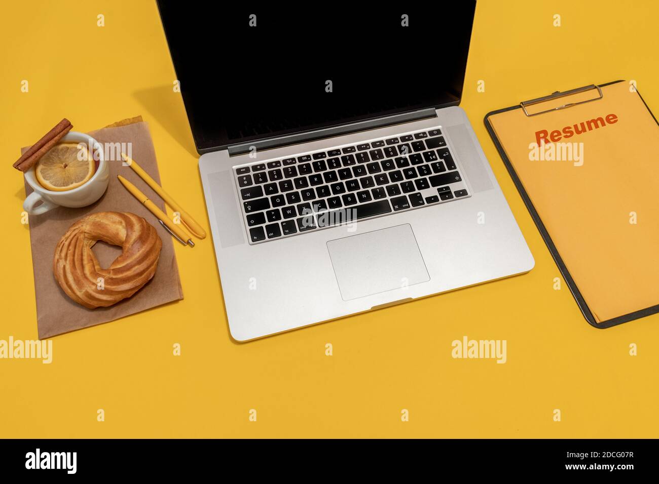 Laptop, Kuchen, Tasse Tee und Lebenslauf Blatt auf der Fortuna Gold Gelb Farbe Hintergrund, Draufsicht. Stockfoto