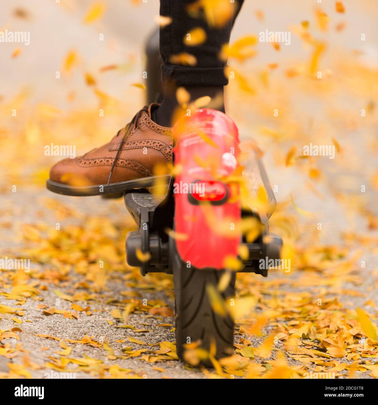 Detail der Fashinable Hipster Mädchen Reiten Elektroroller im Park Im Herbst Stockfoto