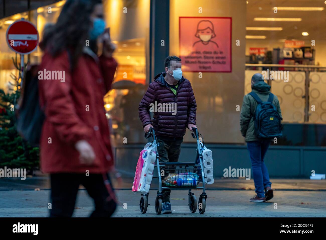 Mann mit Gehhilfe kauft 2 große Packungen Toilettenpapier, die Innenstadt von Bochum, am Tag der Eröffnung der weihnachtlichen Lichtdekoration, normalerweise ein Stockfoto