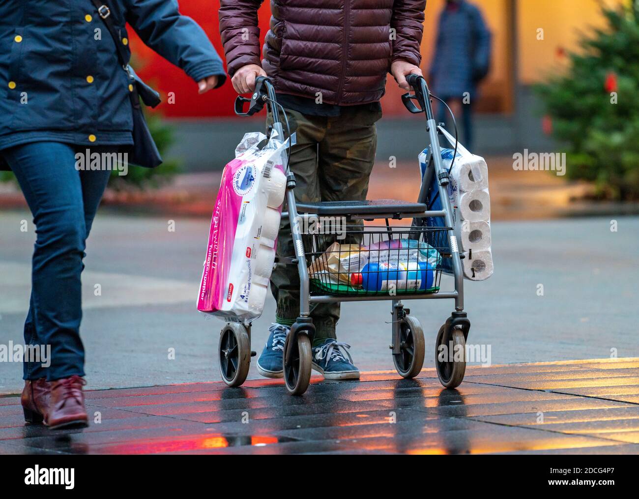 Mann mit Gehhilfe kauft 2 große Packungen Toilettenpapier, die Innenstadt von Bochum, am Tag der Eröffnung der weihnachtlichen Lichtdekoration, normalerweise ein Stockfoto