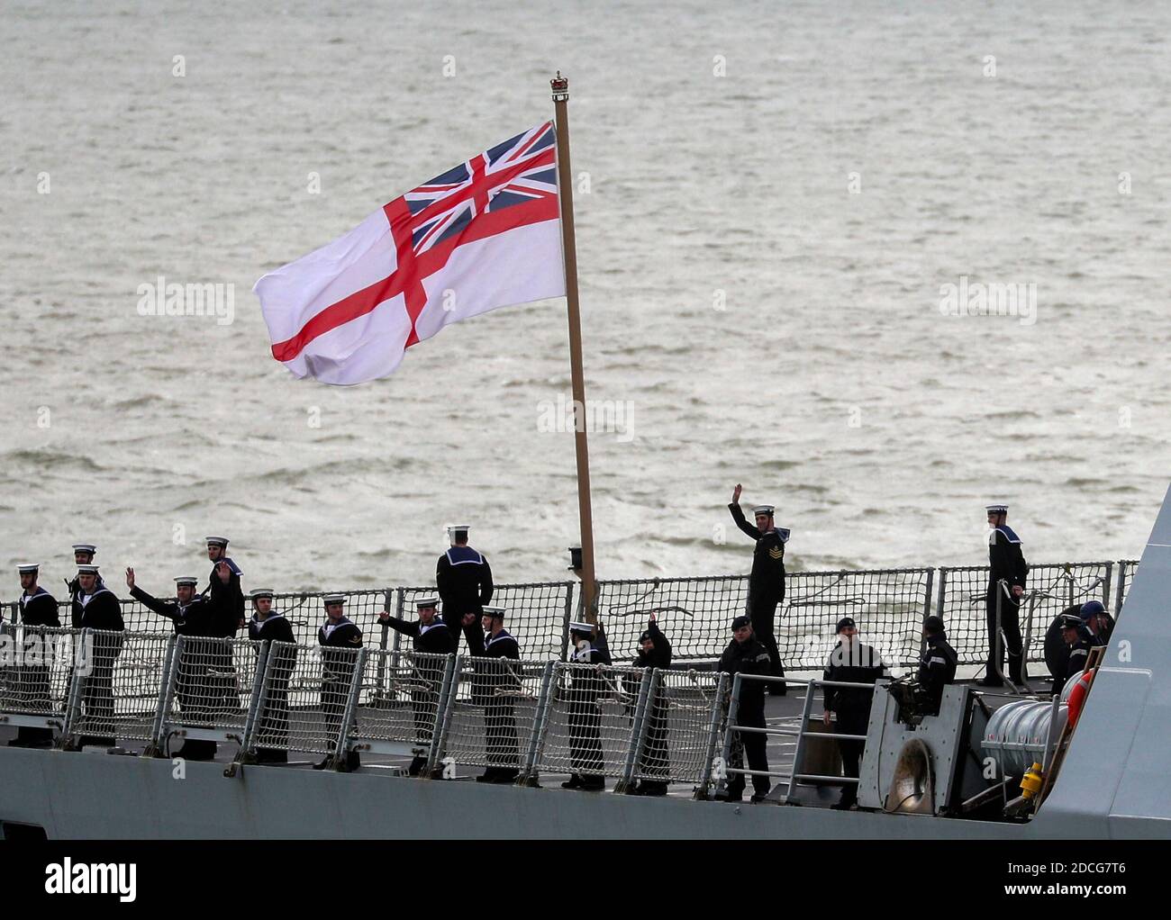 Crew-Mitglieder an Bord von HMS Dragon winken Freunden und Familie, als sie nach einem Training vor der ägyptischen Küste zum Marinestützpunkt Portsmouth zurückkehrt. Stockfoto