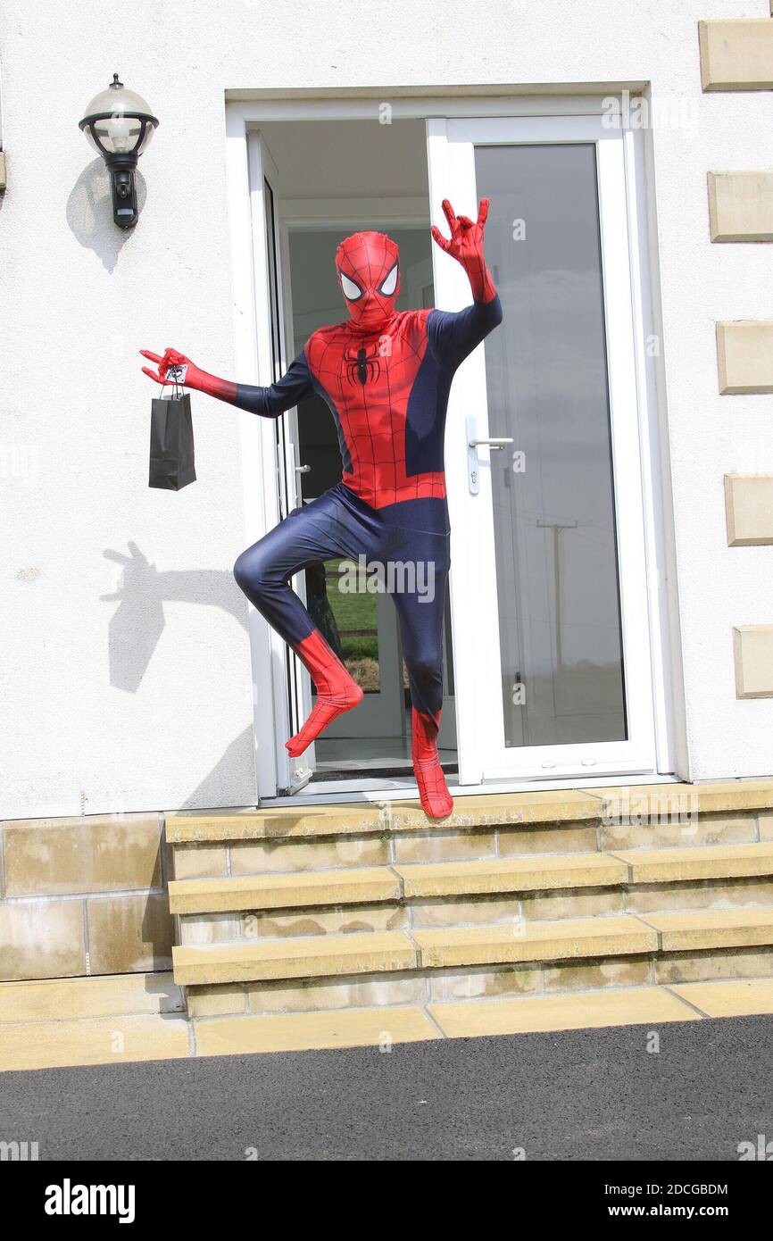 Kostüm Fancy Kleid Charaktere, Mann als Spiderman springt von einer Tür gekleidet Stockfoto
