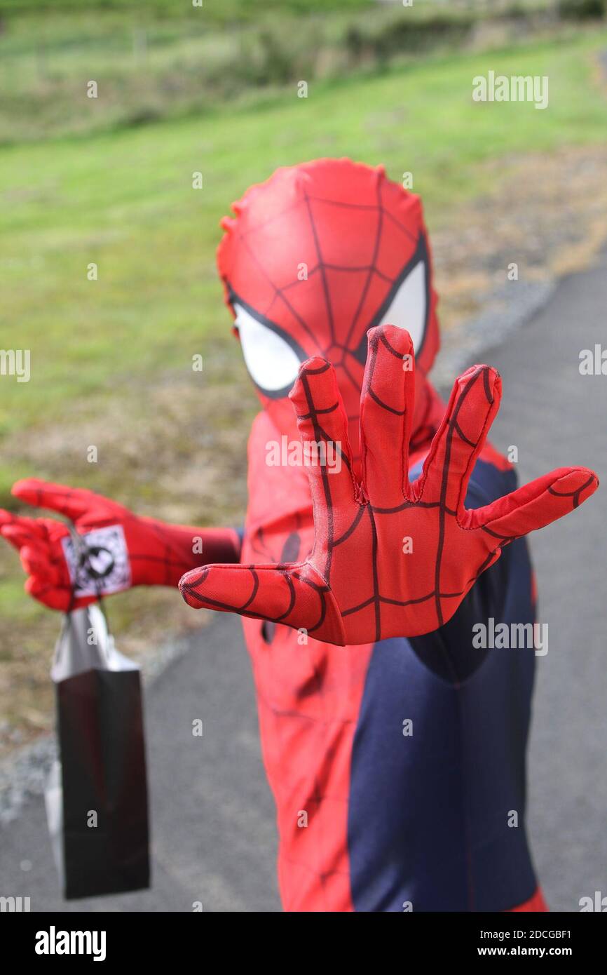 Kostüm Fancy Kleid Charaktere, Mann als Spiderman springt von einer Tür gekleidet Stockfoto