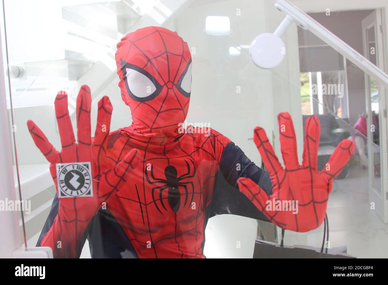 Kostüm Fancy Kleid Charaktere, Mann als Spiderman springt von einer Tür gekleidet Stockfoto