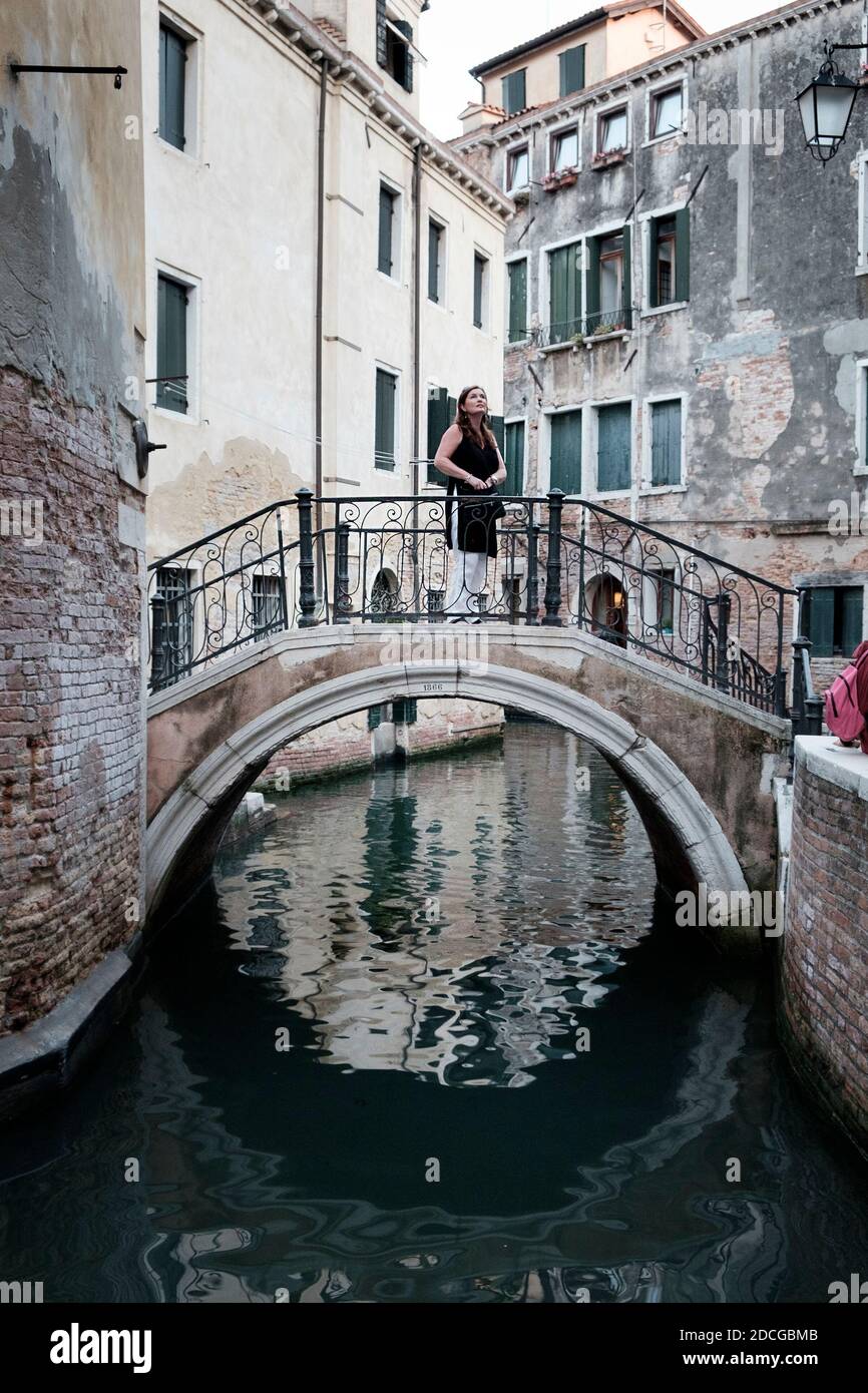 Weibliche Touristen steht auf einer 1866 Steinbrücke über einen Kanal in Venedig, Italien Stockfoto