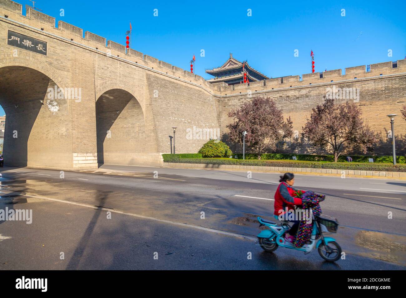 Lokaler Moped-Radfahrer in der Nähe der Stadtmauer von Xi'an, Provinz Shaanxi, Volksrepublik China, Asien Stockfoto