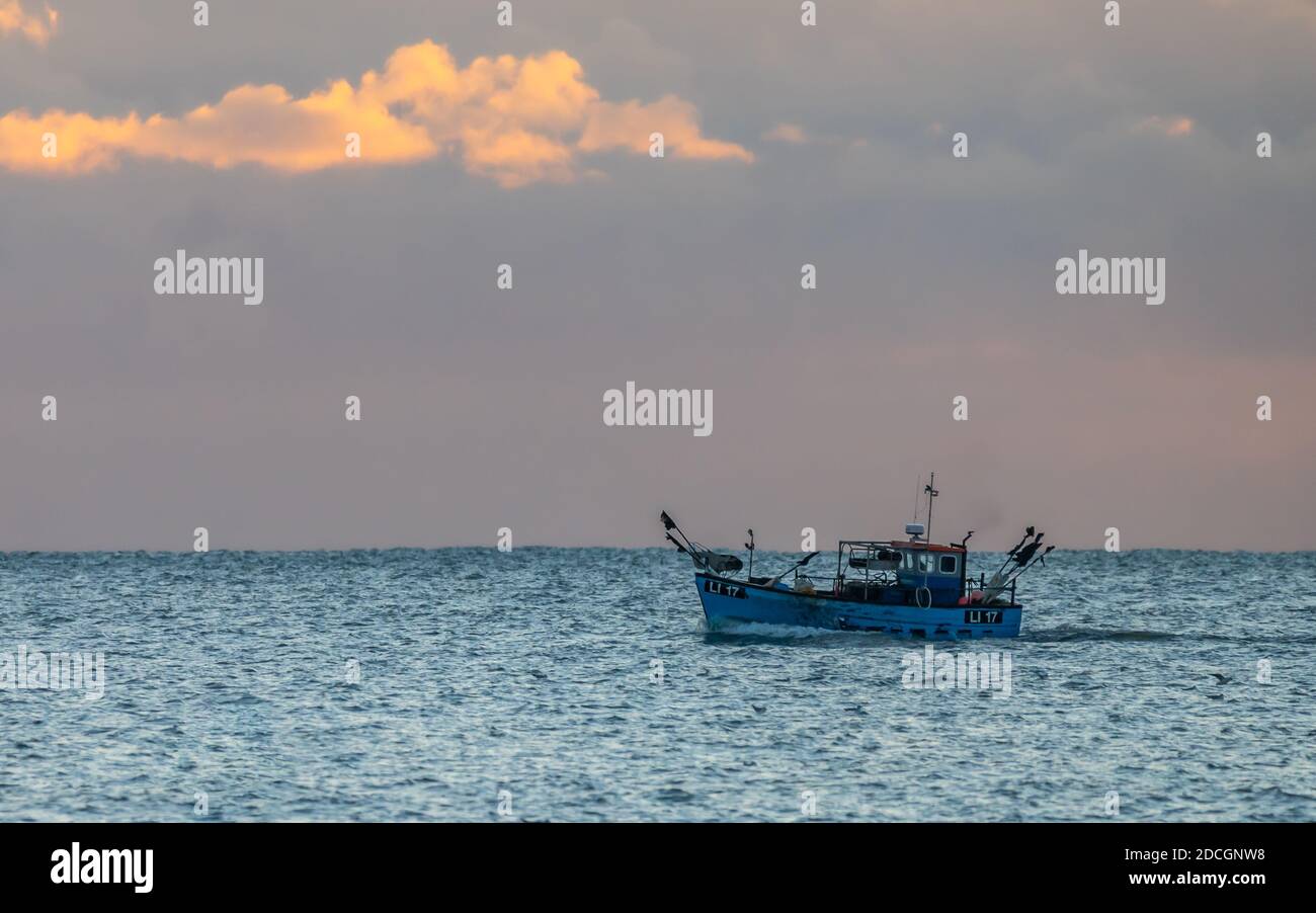 Kleines Fischerboot für eine Person auf See am Abend, wenn die Sonne untergeht, vor der Südküste von West Sussex, England, Großbritannien. Stockfoto