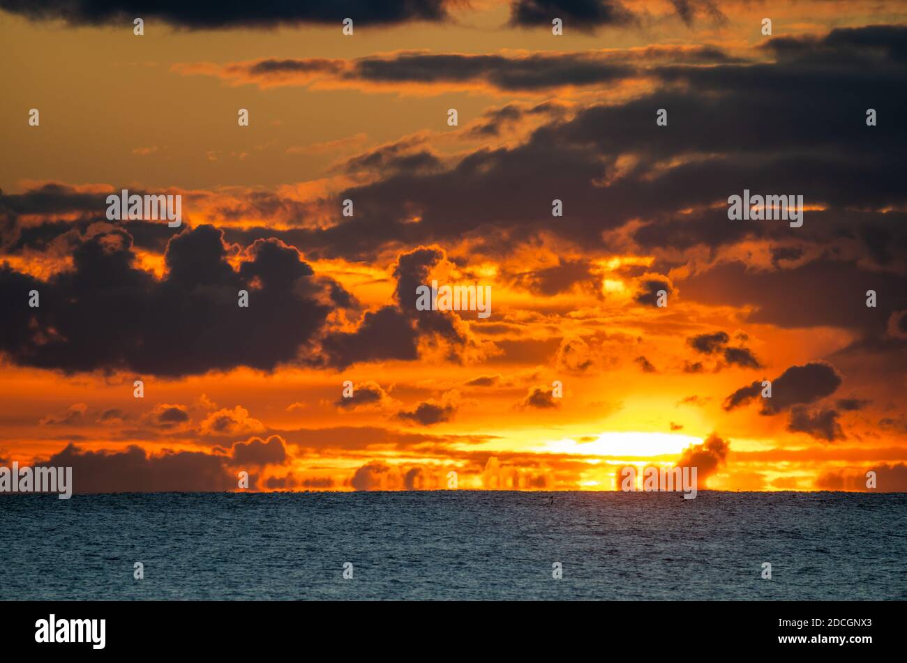 Sonnenuntergang am Meer. Landschaftsansicht der niedrigen Sonne geht über dem Meer mit bewölktem Himmel, in Großbritannien. Stockfoto