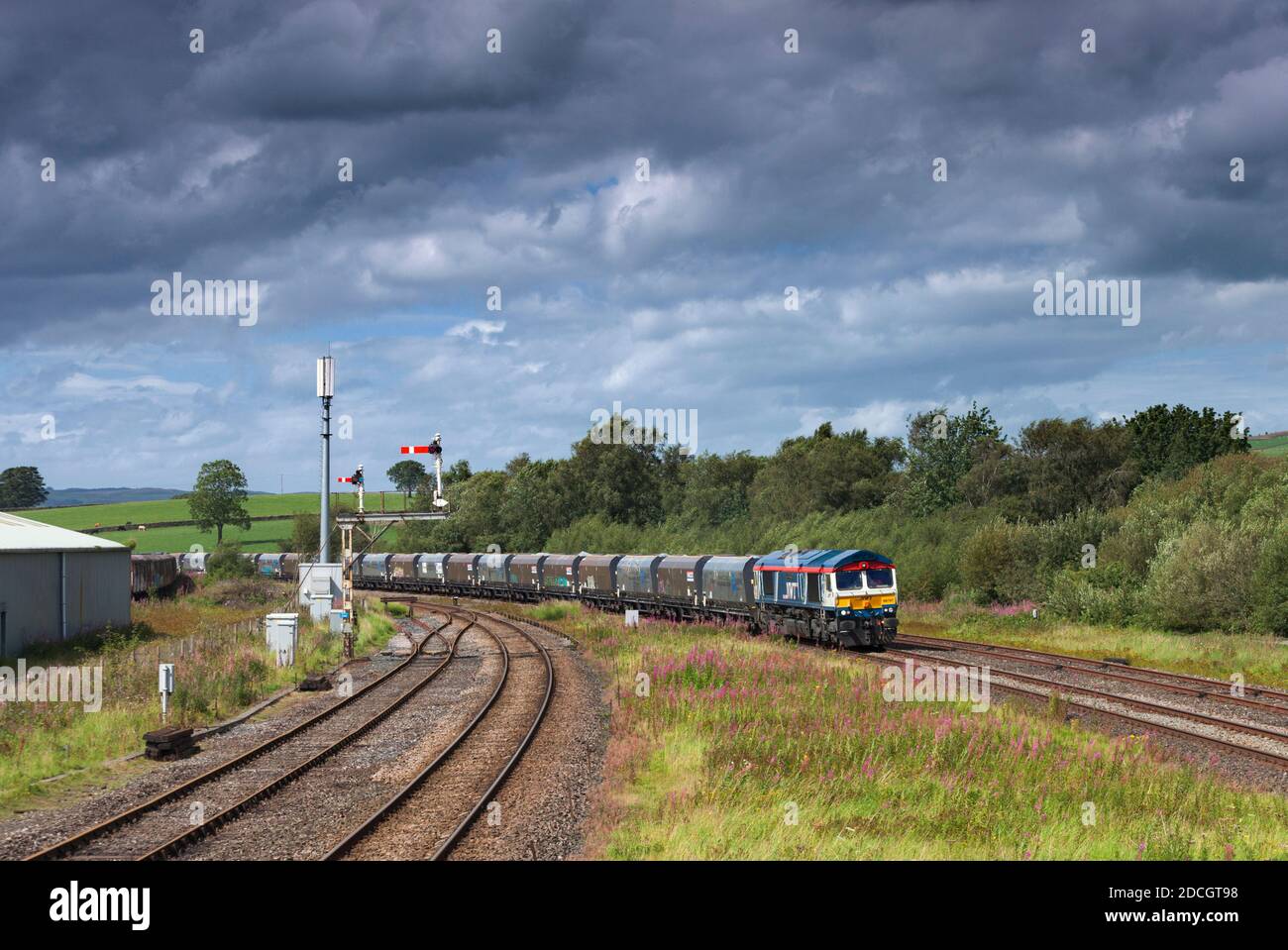 GB Railfeight Baureihe 66 Lokomotive 66747 vorbei Hellifield in der Aire Tal mit einem Güterzug von Zuschlagstofftrichtern Stockfoto