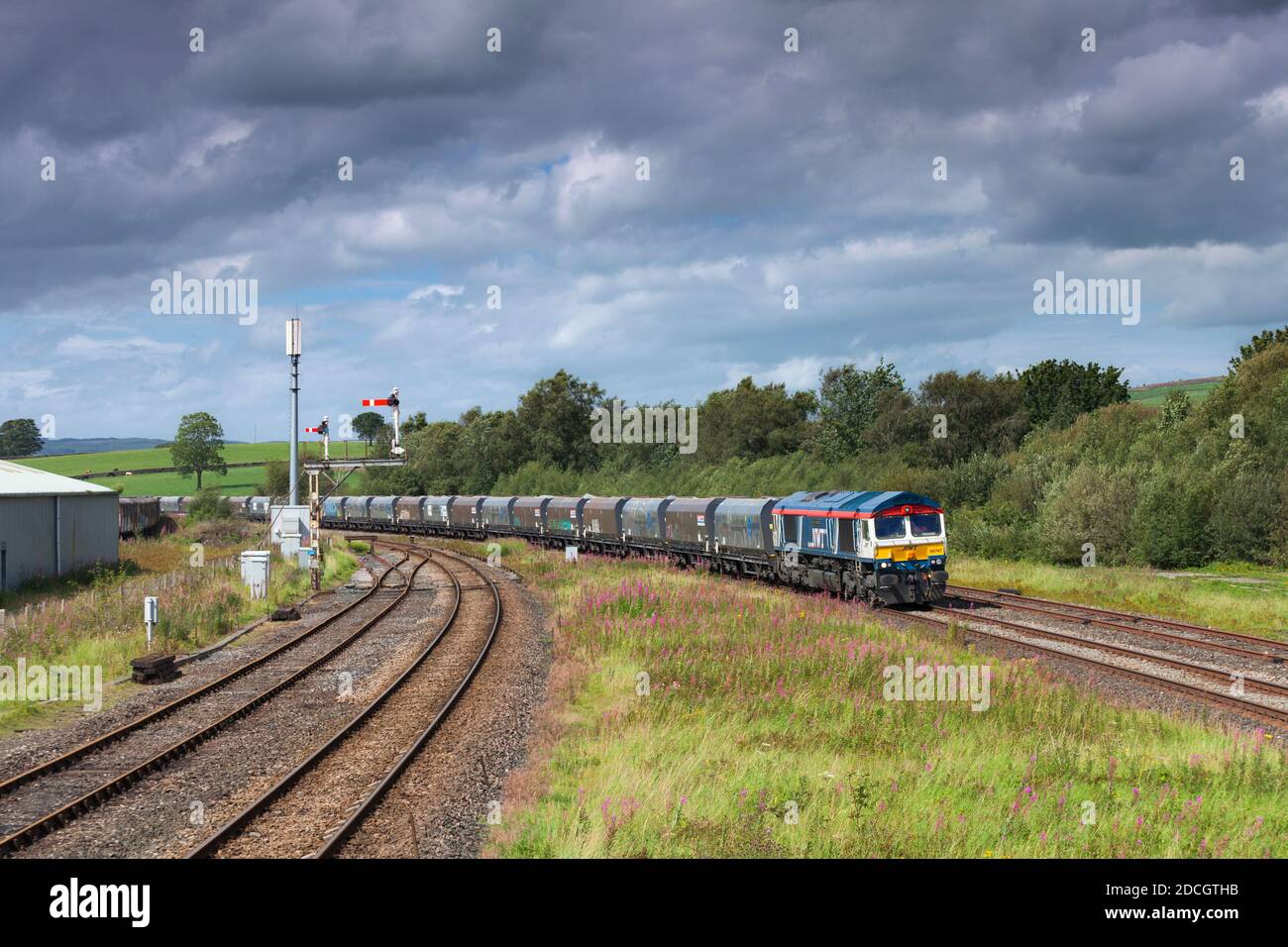 GB Railfeight Baureihe 66 Lokomotive 66747 vorbei Hellifield in der Aire Tal mit einem Güterzug von Zuschlagstofftrichtern Stockfoto