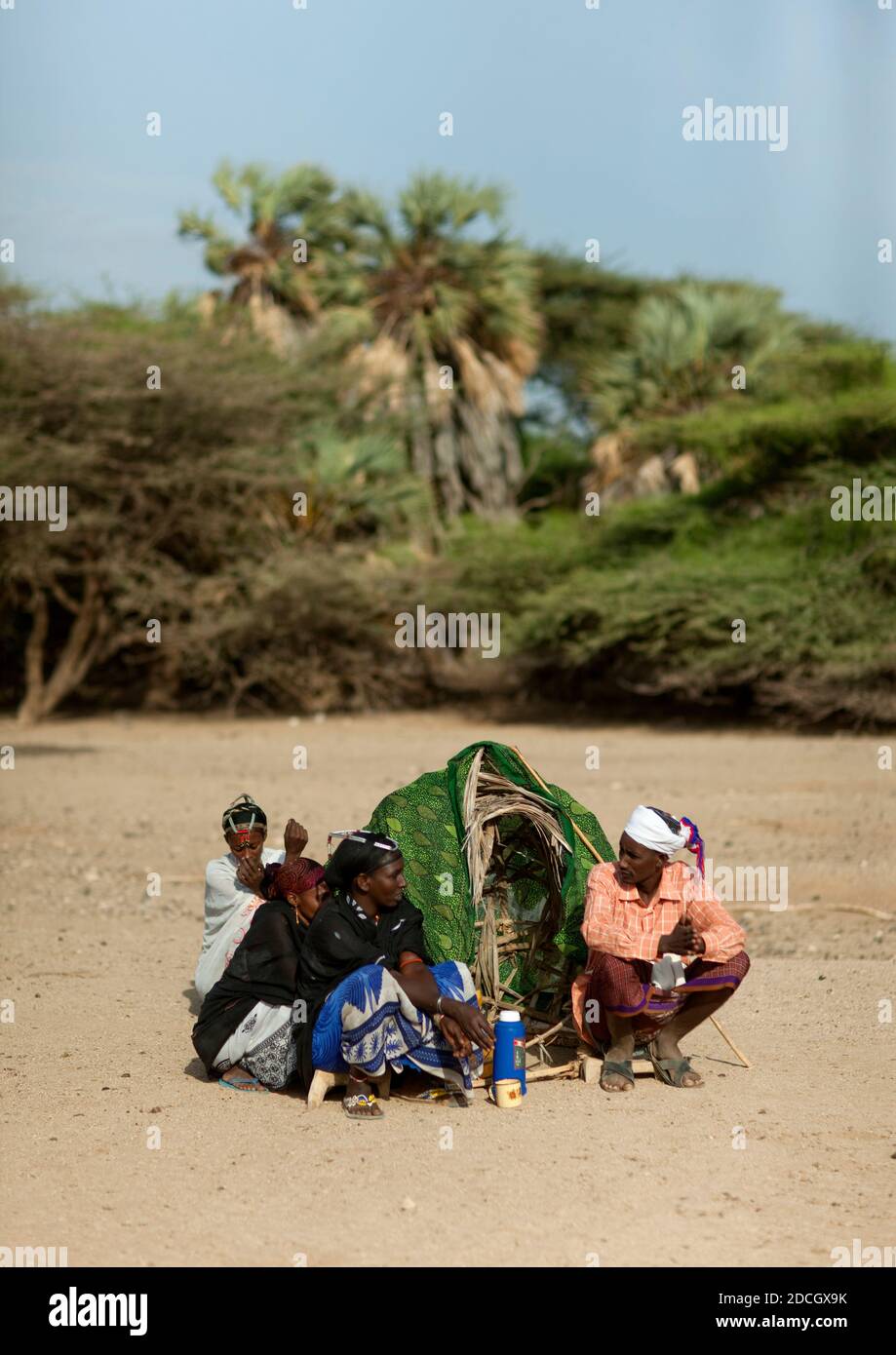 Gabra Stammes Menschen, die um ein kleines Tierheim in der Wüste sitzen, Marsabit County, Chalbi Desert, Kenia Stockfoto