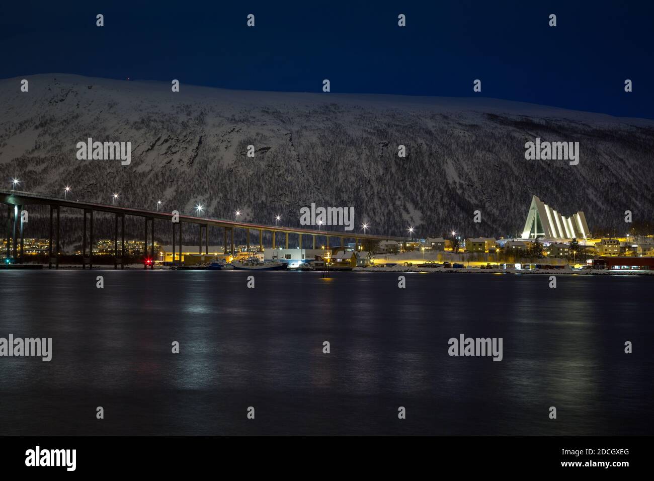 Nachtansicht von Tromsdalen und der beleuchteten arktischen Kathedrale von Tromsø im Winter. Stockfoto