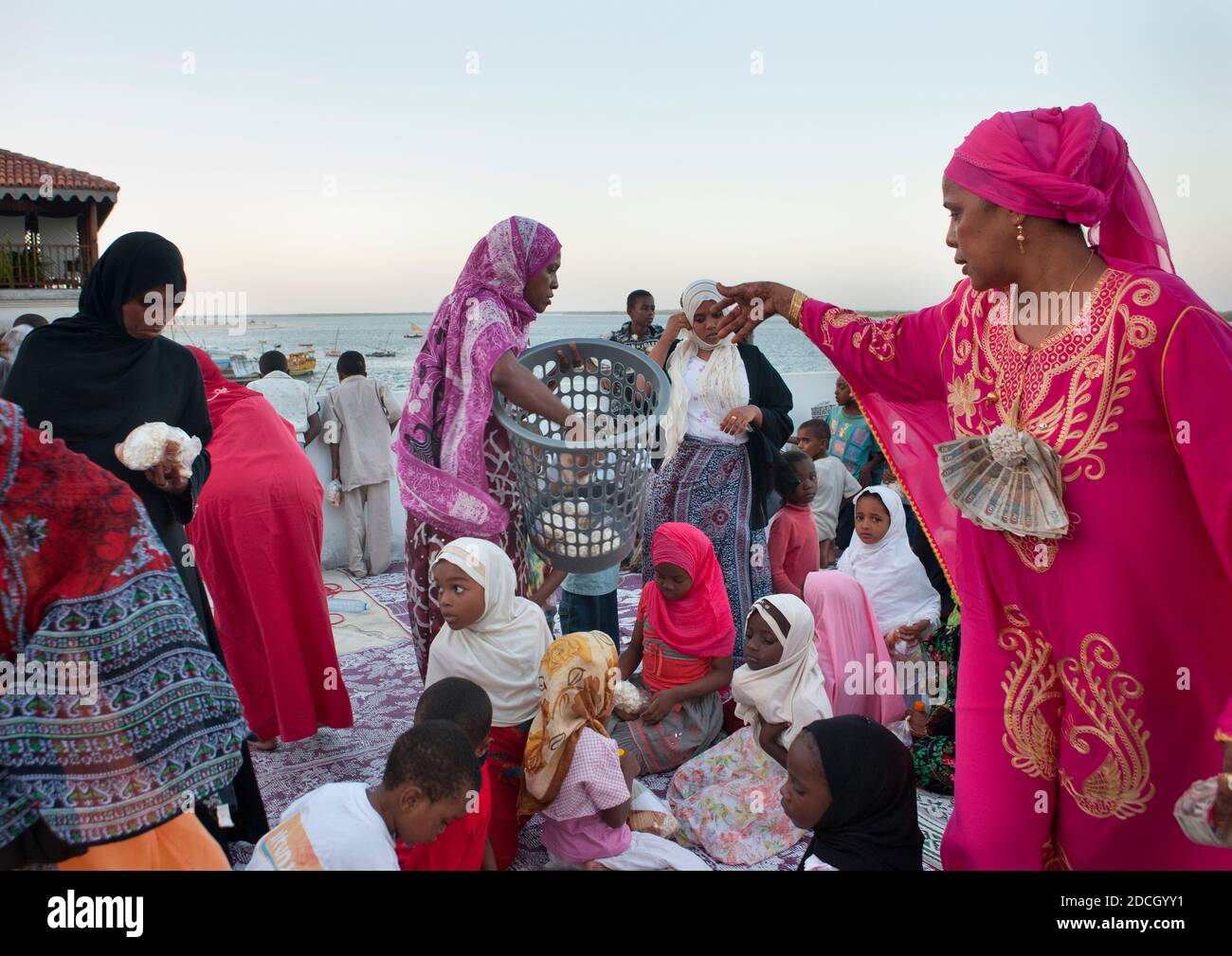Muslimische Frau, die während des Maulid Festivals, Lamu County, Lamu, Kenia, Essen gibt Stockfoto