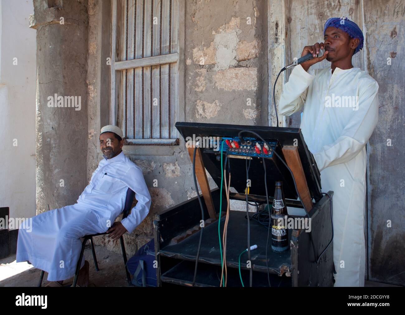 Muslimischer Mann, der während des Maulid-Festivals auf der Straße, Lamu County, Lamu, Kenia, in einem Mikrofon spricht Stockfoto