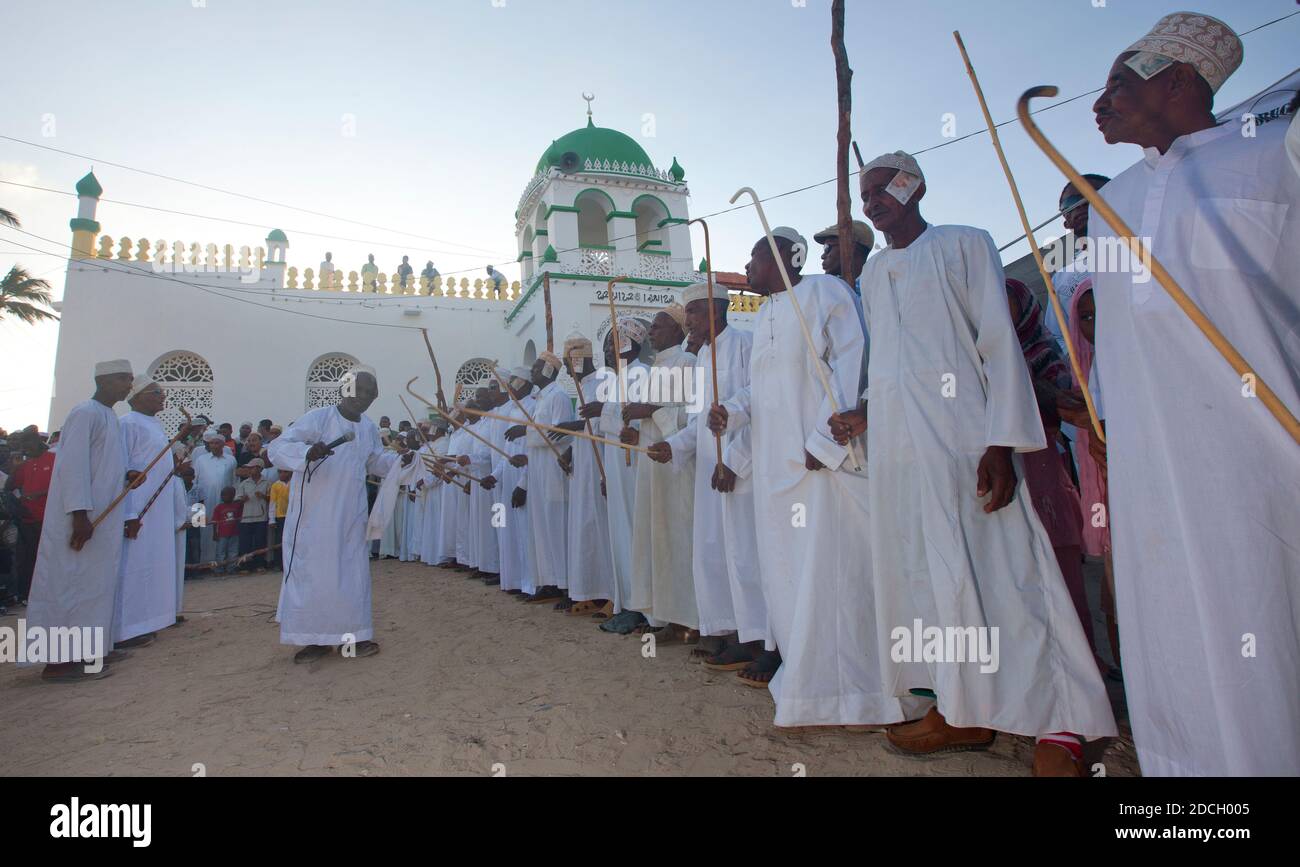 Muslimische Männer singen und tanzen mit goma Sticks während des Maulid Festivals, Lamu County, Lamu, Kenia Stockfoto