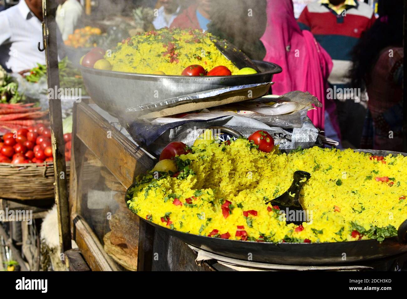 Indisches traditionelles Gericht Poha (Pohe) mit Gemüse und Gewürzen auf dem Markt. Verkäufer mit Frühstück Street Food Morgen, Pushkar, Rajastan, Indien Stockfoto