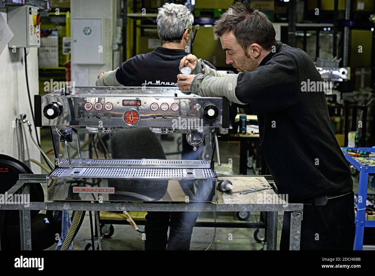 Männlicher Angestellter in der Fabrik La Marzocco, der an der Espressomaschine arbeitet, Scarperia, Florenz, Italien Stockfoto