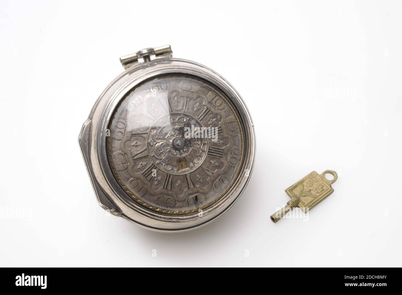 Watch, Willem Leopoldus, c. 1740, auf dem Uhrwerk: Willem Leopoldus Leyden, Glas, Textil, Silber, graviert, Allgemein: 5.6 x 3.1 x 2,9cm 56 x 31 x 29mm, Blume, Sonne, Löwe, Uhr mit silbernem Uhrwerk in einem Uhrengehäuse, das innen mit rotem Textil ausgekleidet ist. Der hinter Glas liegende Zeitmesser ist in der Mitte mit Wim Leopoldus Leyden eingraviert und enthält die Stunden in römischen Ziffern, über denen die Minuten in Ziffern angegeben sind. Die Uhr hat einen Uhrenschlüssel mit auf der einen Seite das Bild eines Löwen und einer Sonne und auf der anderen Seite eine Blume, 1976 Stockfoto