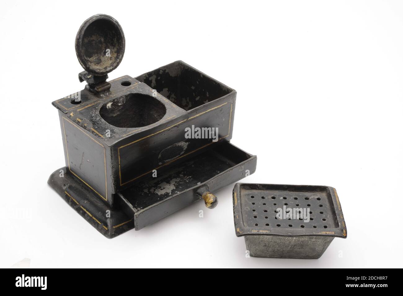 Inkwell, Anonymous, erste Hälfte des 18. Jahrhunderts, schwarz lackierter Zinn-Tintenfass mit goldenen Linien verziert. Mit Sandkasten und Schublade mit Knopf unten. Das rechteckige ganze ist auf einer breiteren Basis. Der konvexe Deckel ist mit goldenen Strahlen verziert, allgemein: 8 x 12.9 x 8,1cm 80 x 129 x 81mm Stockfoto