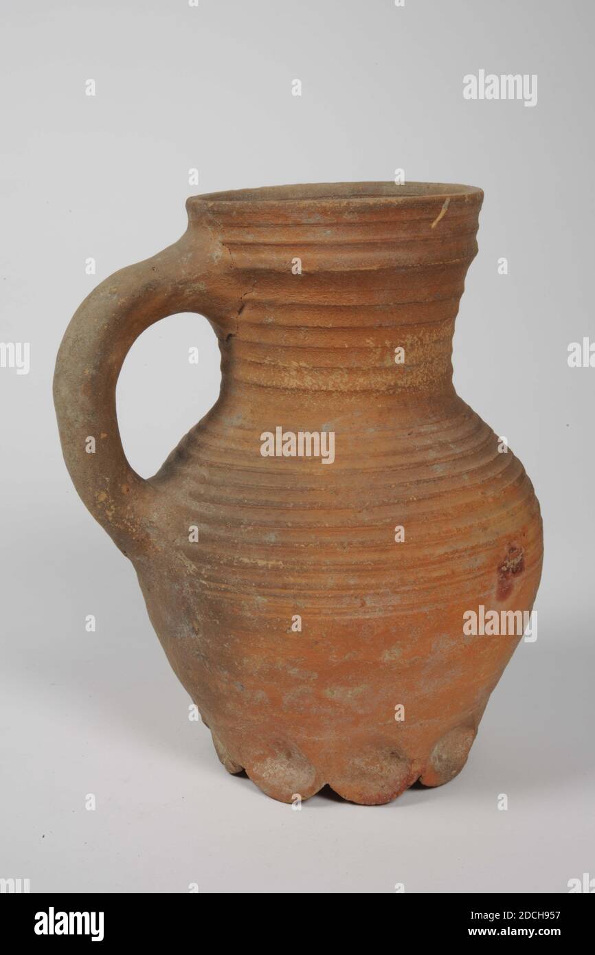 Jug, Anonymous, ca. 1300, Bleiglasur, Steingut, allgemein: 22 x 17.5 x 16cm 220 x 175 x 160mm, Krug mit Griff aus rot gebranntem Steingut mit Bleiglasur. Es hat neun gelappte Beine, einen eiförmigen Körper, einen verengten Hals und einen trichterförmigen Hals. Der Körper hat grob rotierende Ringe und ein gezackter Band auf der Schulter in Relief. Unten ein Etikett: Rodenburch Leiden, 1972 Stockfoto