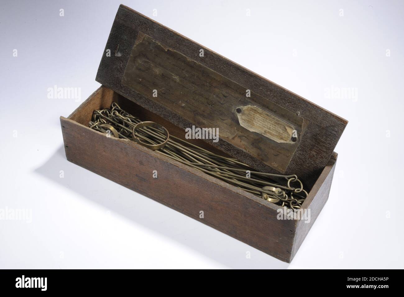 Anonym, 1752, Holz, Messing, Kette: 1 x 1848 x 6,3 cm 10 x 18 480 x 63 mm, Brust: 10.7 x 43 x 16 cm 107 x 430 x 160 mm, Deckel: 1 x 42.5 x 14,2cm 10 x 425 x 142mm, Messingkette aus fünf rheinischen Stäben mit 50 Gliedern, mit einem größeren Ring alle fünf Glieder. Eingraviert auf den Endringen: Res: 19 Meij 1752 E.V.D.L. und das Wappen von Leiden. Die Vermessungskette ist in einer länglichen Holzkiste mit Schiebedeckel verpackt. Am Deckel ist eine Papierhandschrift angebracht und ein gedrucktes Etikett angebracht. Das Manuskript ist schwer zu lesen, Stadtwappen Stockfoto