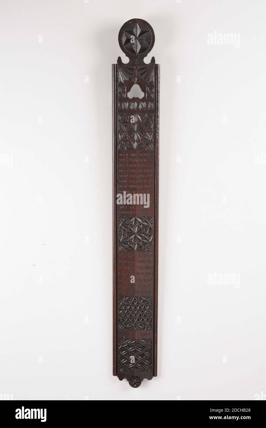 Bügelbrett, Pieter Volkers, 1810, geschnitzt, Allgemein: 1.5 x 74 x 9cm 15 x 740 x 90mm, rechteckige Bügelbrett mit einem geschnittenen Kreis auf dem Kopf, verziert mit einem Stern. Die Planke ist in gekerbter Schnitzerei mit zwei Viertelkreisen und vier Quadraten mit geometrischen Mustern gefüllt, zwischen drei Inschriften verziert: WENN ICH IM DIENST BIN UND DIE WÄSCHE GLATT MACHE, DANN GY MYN ABER, UND DANN SCHON ABER FRAU AUCH DAS HÖREN, DASS GY AUCH WÄSCHT IHRE WÄSCHE SO FIT WEISS WIE EINE GUTE FRAU UND: PIETER VOLKERS IST MEIN NAME, DER AUCH DIESE PLATTE KAM MACHEN BEREITS QUALIFIZIERTEN RAKE, 1810. MAI 1914 Stockfoto