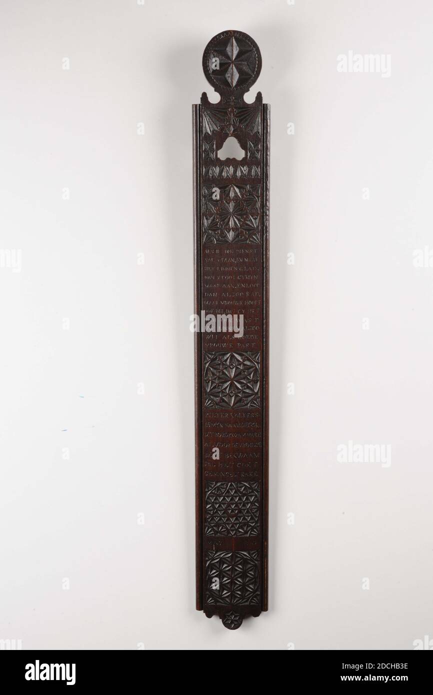 Bügelbrett, Pieter Volkers, 1810, geschnitzt, Allgemein: 1.5 x 74 x 9cm 15 x 740 x 90mm, rechteckige Bügelbrett mit einem geschnittenen Kreis auf dem Kopf, verziert mit einem Stern. Die Planke ist in gekerbter Schnitzerei mit zwei Viertelkreisen und vier Quadraten mit geometrischen Mustern gefüllt, zwischen drei Inschriften verziert: WENN ICH IM DIENST BIN UND DIE WÄSCHE GLATT MACHE, DANN GY MYN ABER, UND DANN SCHON ABER FRAU AUCH DAS HÖREN, DASS GY AUCH WÄSCHT IHRE WÄSCHE SO FIT WEISS WIE EINE GUTE FRAU UND: PIETER VOLKERS IST MEIN NAME, DER AUCH DIESE PLATTE KAM MACHEN BEREITS QUALIFIZIERTEN RAKE, 1810. MAI 1914 Stockfoto