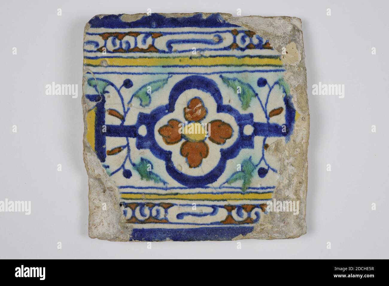 Wandfliesen, Anonymous, ca. 1600, Zinnglasur, Steingut, allgemein: 13 x 13 x 1,7cm (130 x 130 x 17mm), Blume, nordniederland, Randfliese aus Steingut mit Zinnglasur bedeckt. Bunt bemalt in blau, grün, gelb und orange braun mit einem mehrfarbigen horizontalen Muster aus stilisierten Blumen- und Blattmotiven und geometrischen Mustern, 1985 Stockfoto