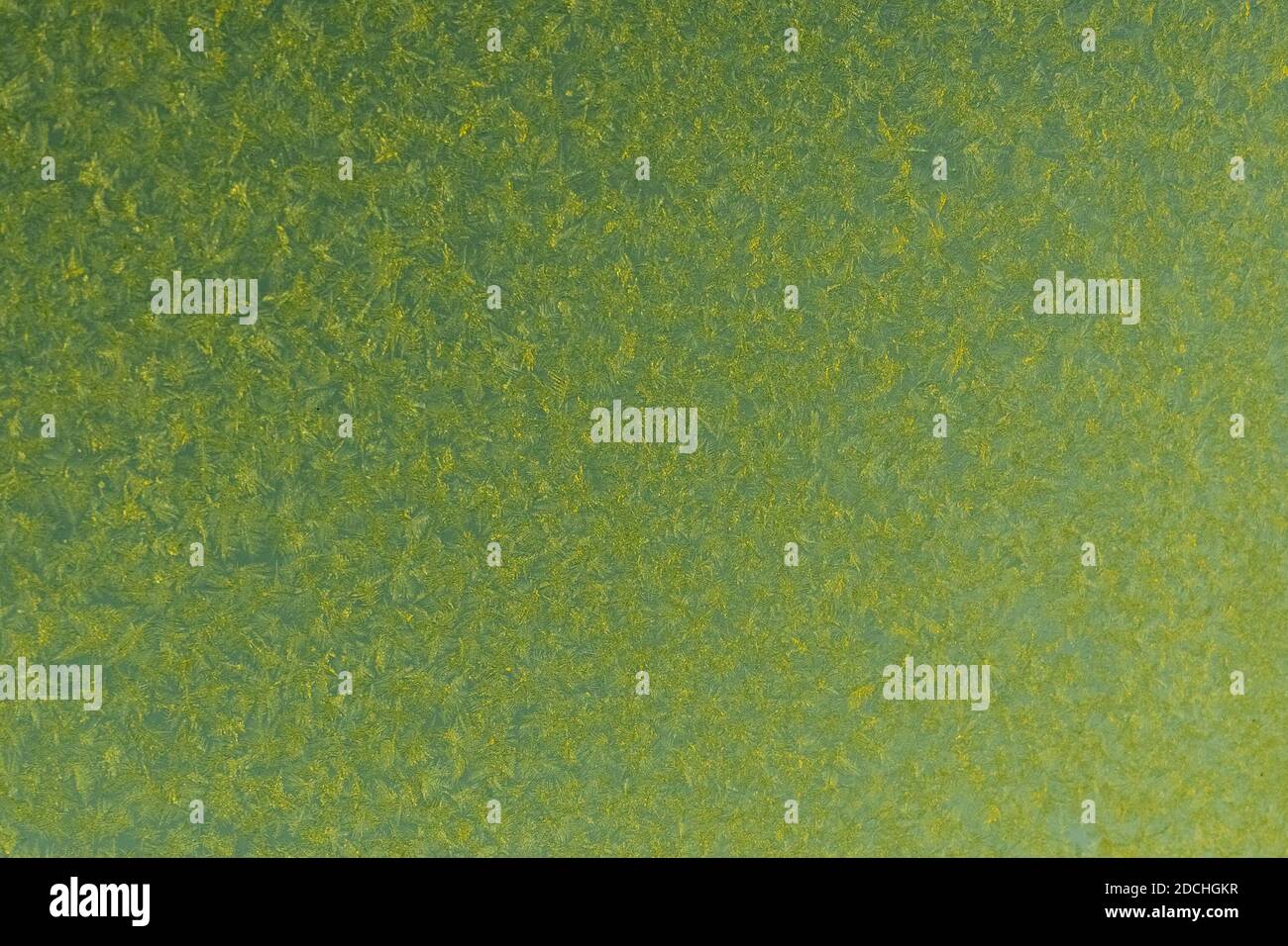 Gelber Frost auf einem Glashintergrund. Gefrosttes Glas mit Struktur. Stockfoto