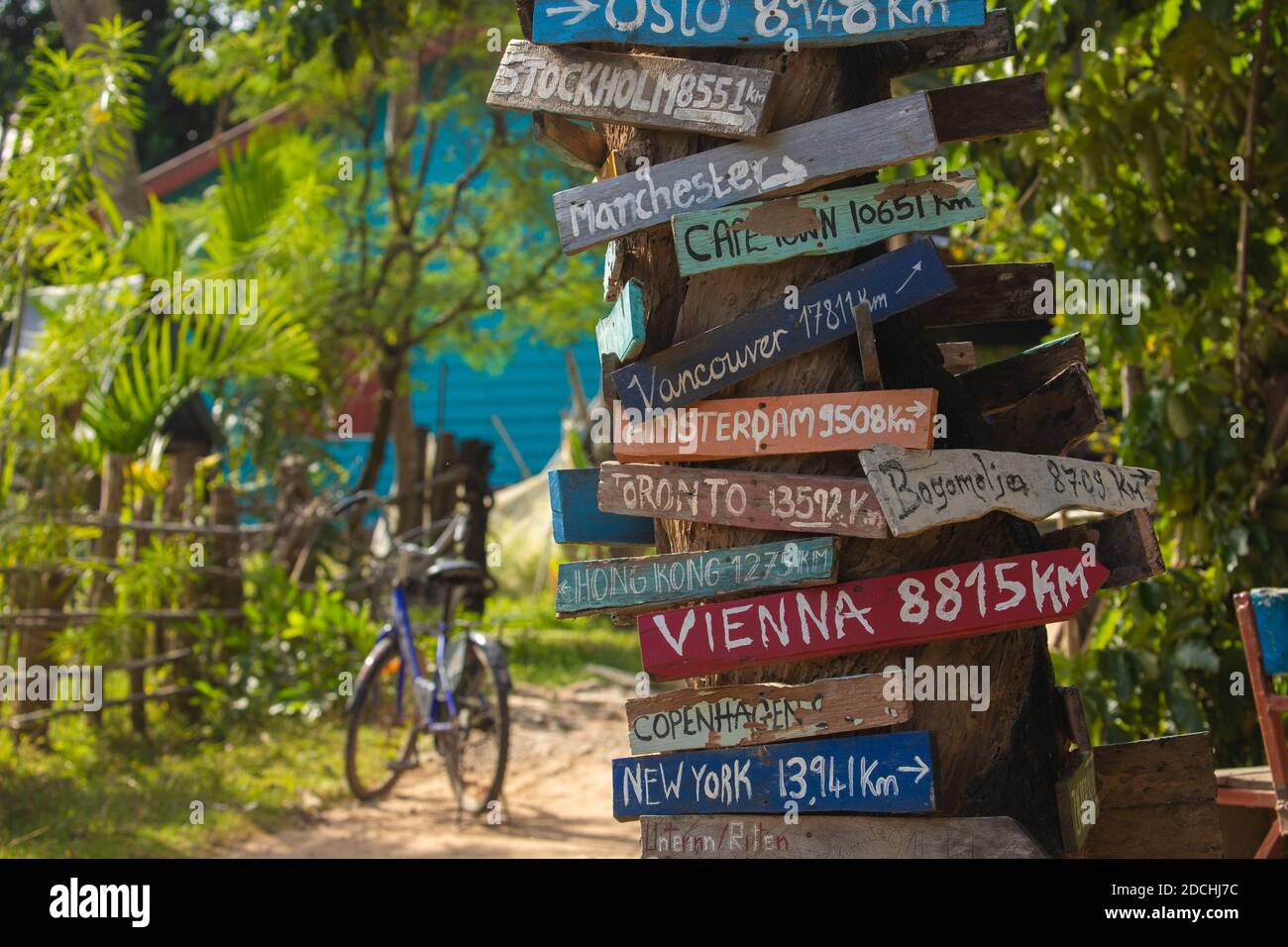 Bunte handbemalte Richtung Holz Zeichen zu verschiedenen Städten der Welt, und Meilenzeiger in Don det Insel, einer der berühmten viertausend ist Stockfoto