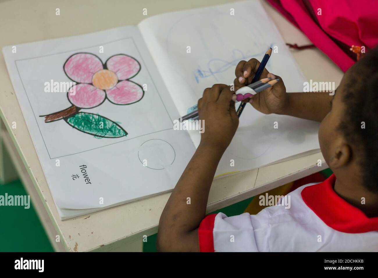 Eine Pre-Schooler macht ihre Zeichnungen einer Blume. Stockfoto