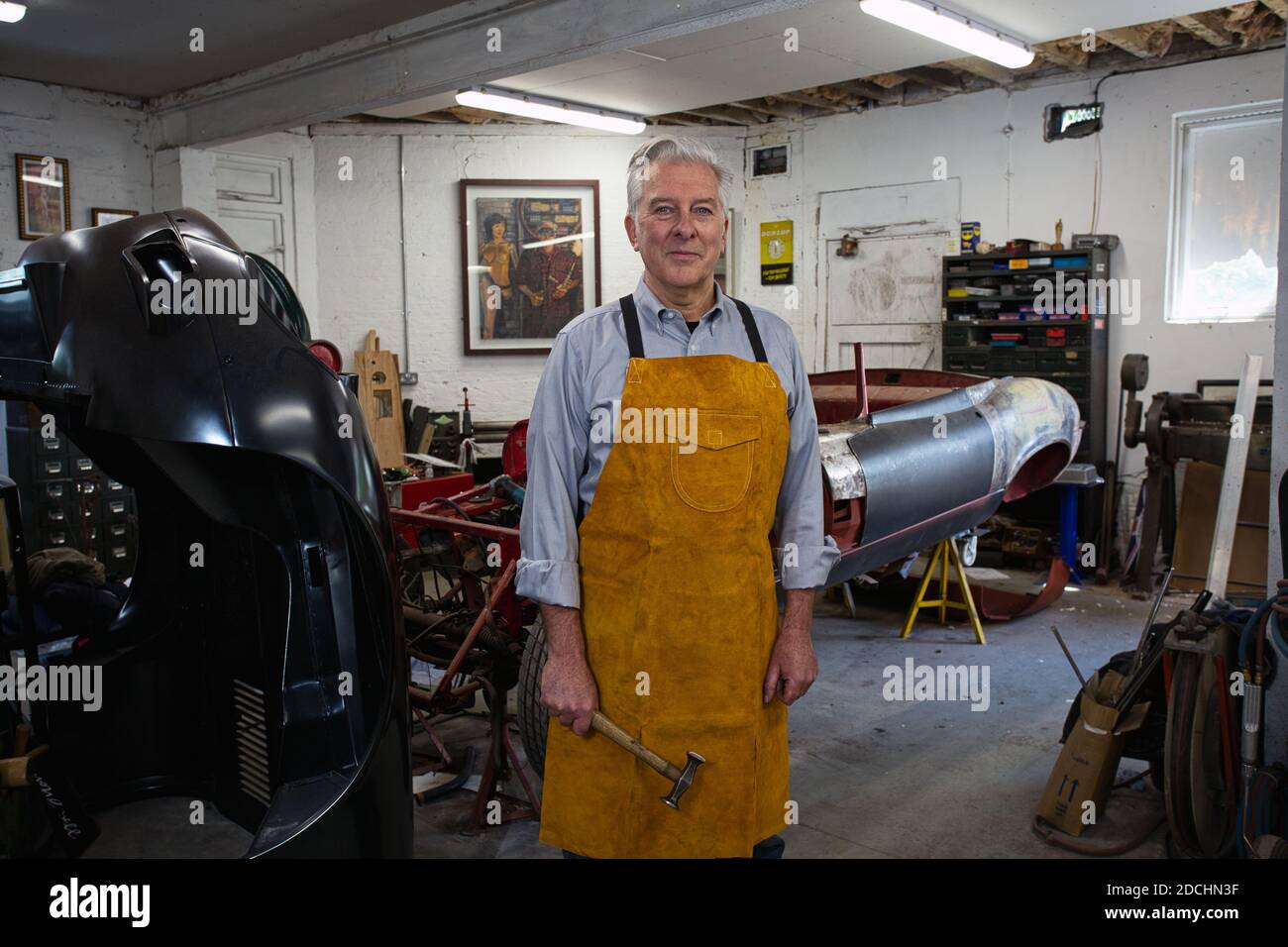 Mechaniker, der Werkzeug in einer Werkstatt hält. Stockfoto